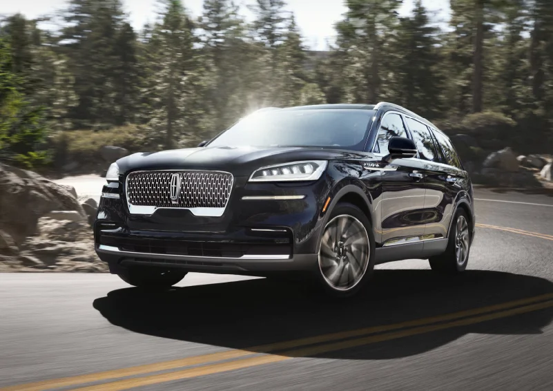 A 2024 Lincoln Aviator driving through a forest