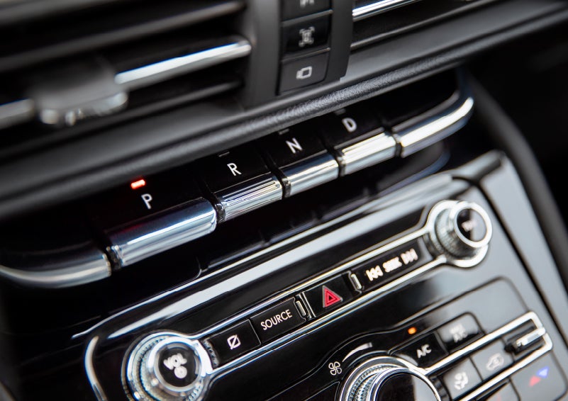 The Park button on the elegant Piano Key Shifter is lit up and engaged as light dances off the chrome accents and horizontal design lines | Bob Maxey Lincoln in Detroit MI