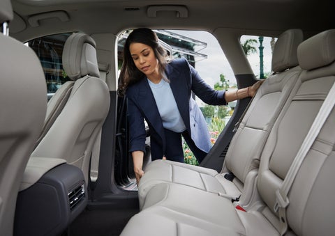 A woman slides the second-row seat forward to create more cargo space | Bob Maxey Lincoln in Detroit MI