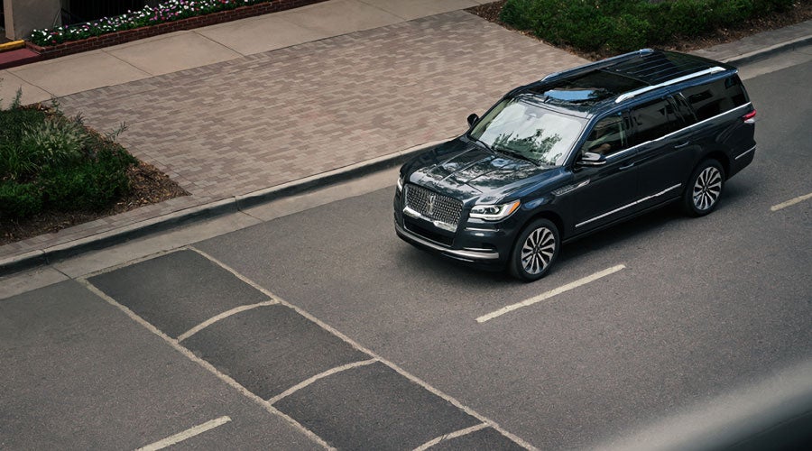 A 2022 Lincoln Navigator SUV in Flight Blue is approaching a speed bump