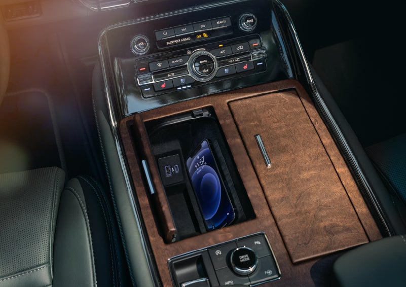 A smartphone is charging on the wireless charging pad in the front center console cubby | Bob Maxey Lincoln in Detroit MI