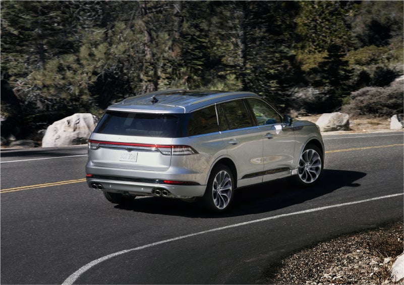 A 2023 Lincoln Aviator® Grand Touring model is shown being driven on a tight turn of a mountain road | Bob Maxey Lincoln in Detroit MI
