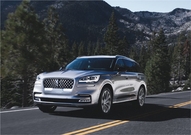 A 2023 Lincoln Aviator® Grand Touring SUV being driven on a winding road to demonstrate the capabilities of all-wheel drive | Bob Maxey Lincoln in Detroit MI