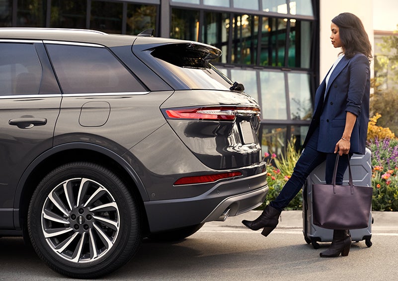 A woman with her hands full uses her foot to activate the available hands-free liftgate. | Bob Maxey Lincoln in Detroit MI