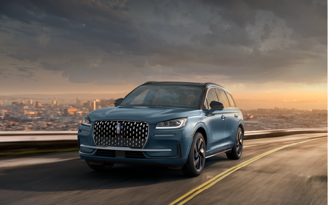 A 2025 Lincoln Corsair® Grand Touring SUV is being driven on a hillside road.
