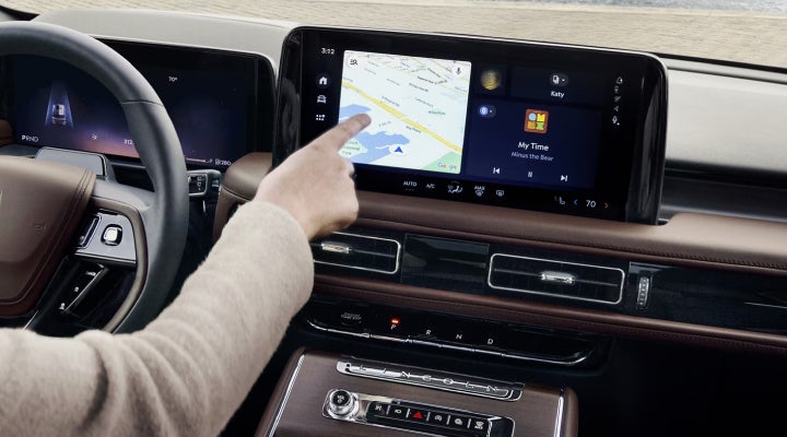 A person is tapping the center display touchscreen of a 2026 Lincoln Aviator® SUV. | Bob Maxey Lincoln in Detroit MI