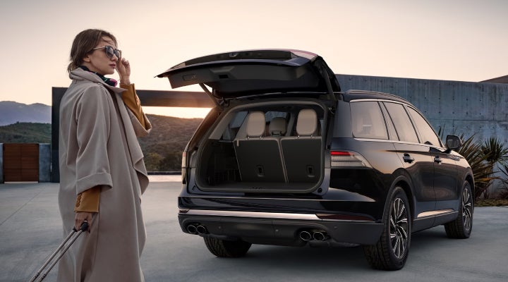 A woman approaches a 2026 Lincoln Aviator® SUV with its rear liftgate open. | Bob Maxey Lincoln in Detroit MI