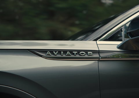 The driver’s side door and fender badging of a gray 2027 Lincoln Aviator® SUV are showcased. | Bob Maxey Lincoln in Detroit MI