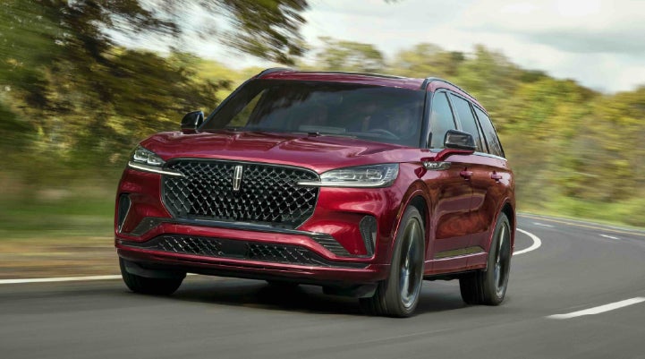 A 2027 Lincoln Aviator® SUV is being driven on a country road | Bob Maxey Lincoln in Detroit MI